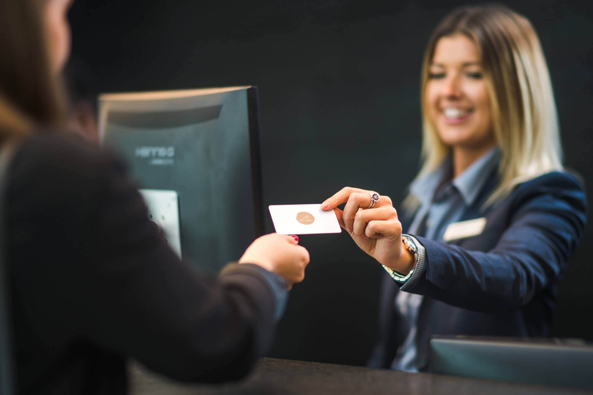 Staff member giving guest key at reception Staff member giving guest key at reception