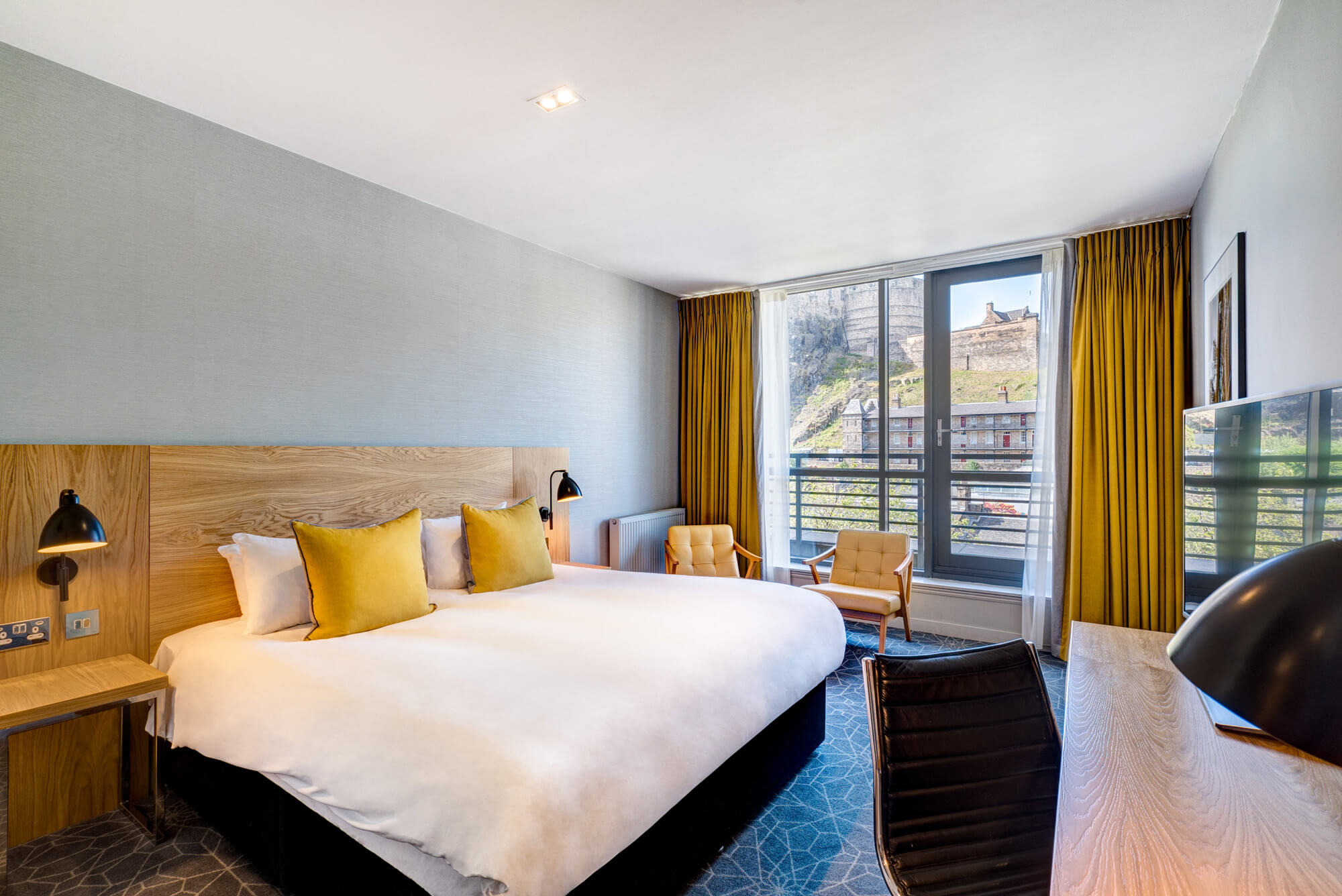 Double bed with views onto Edinburgh Castle in Apex Grassmarket's Deluxe Castle View Room