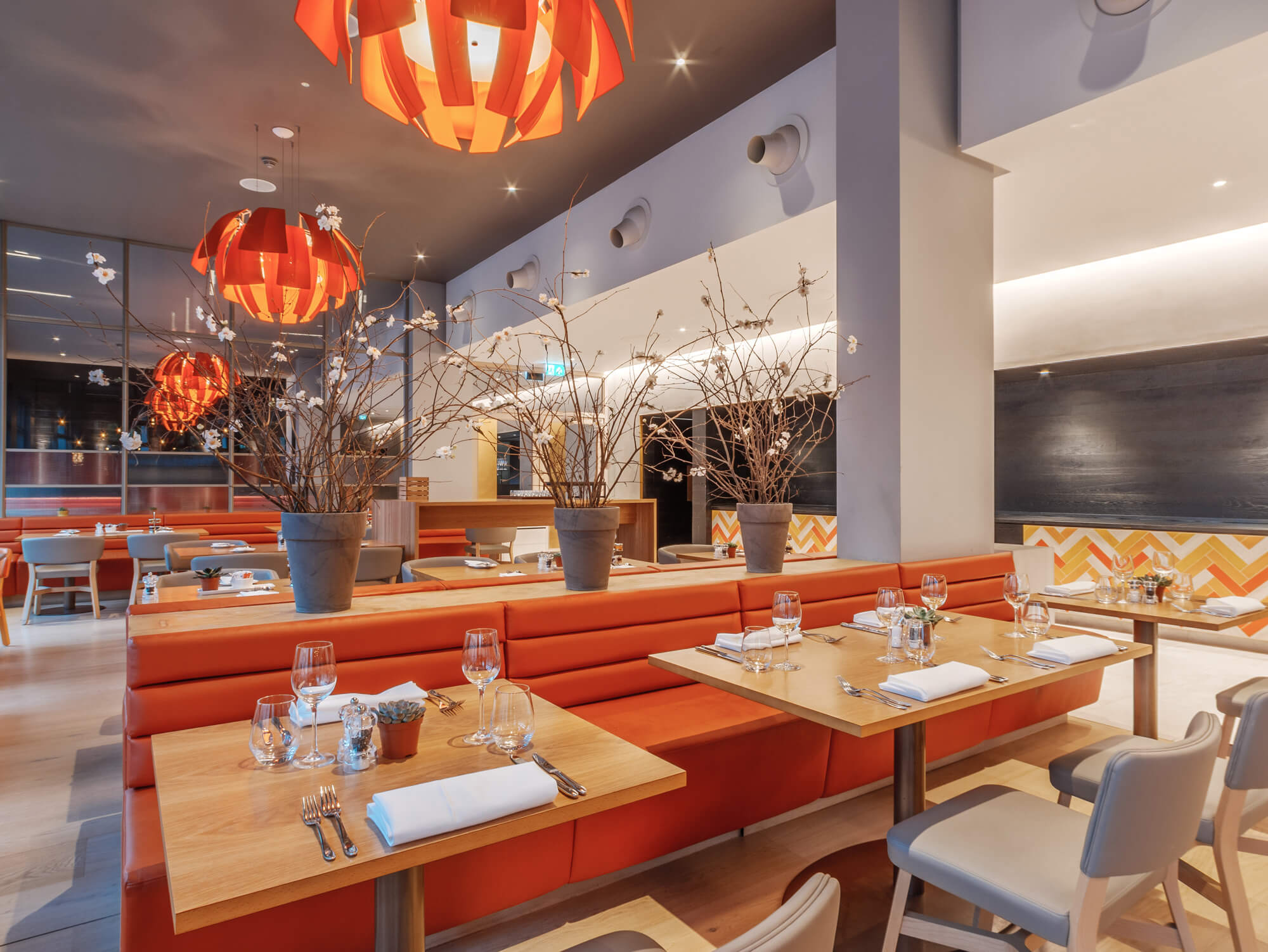 The Orange Artichoke restaurant at Apex City of Bath Hotel with orange chairs and tables