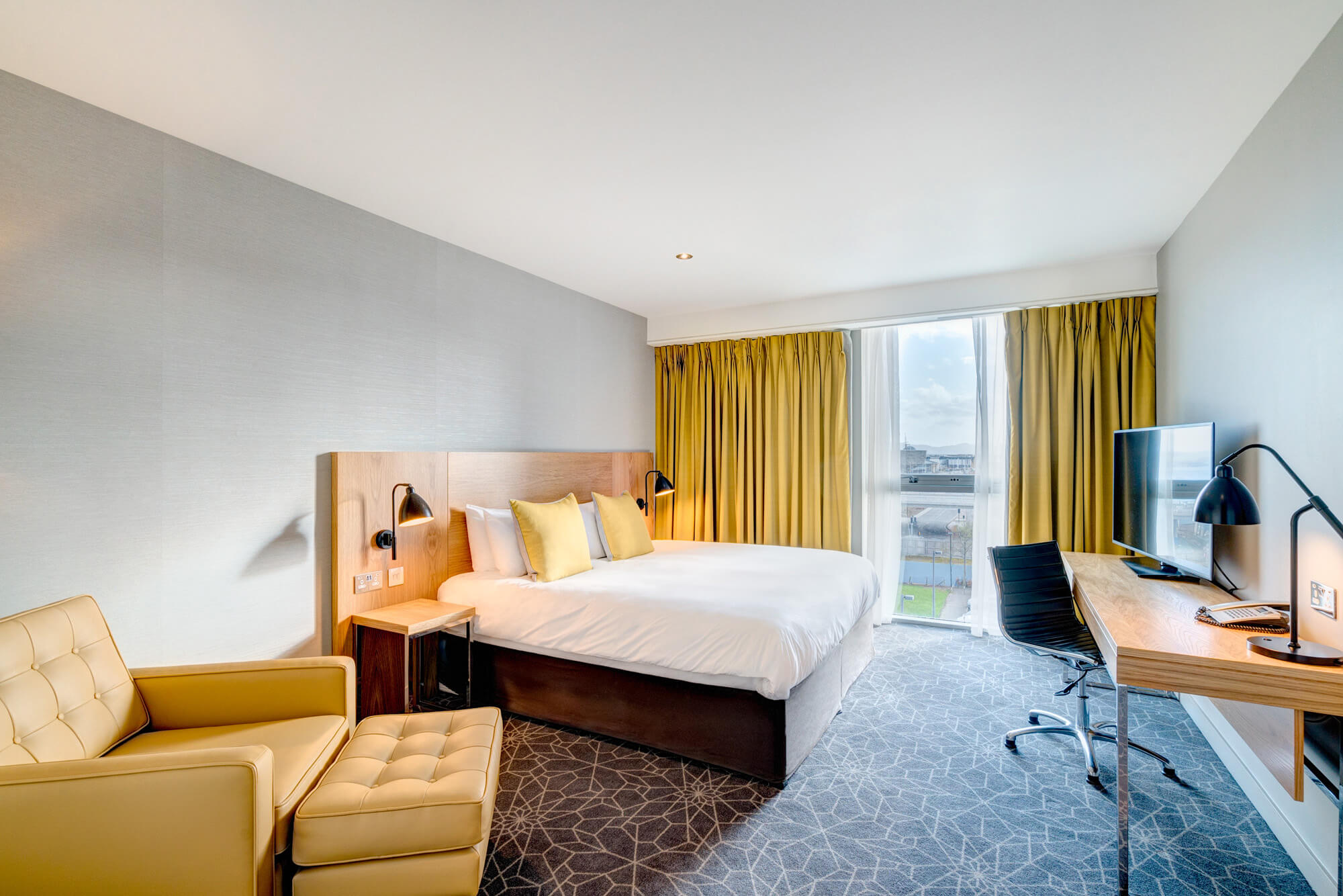 Apex City Quay Hotel City Bedroom with double bed, large desk and arm chair